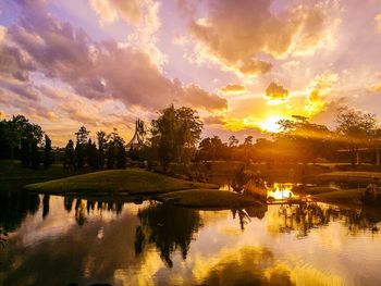 Reflection of trees in lake against sky during sunset