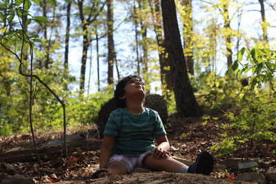 Portrait of boy sitting in forest