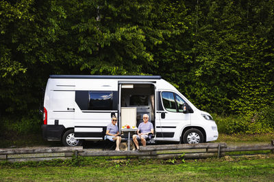 Senior couple sitting in front of trailer