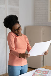 Architect woman holding plan at home