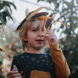 Portrait of cute boy wearing leaves