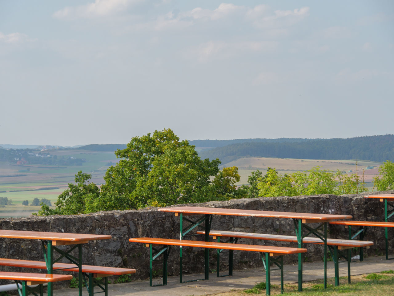 EMPTY CHAIRS AND TABLE AGAINST TREES ON MOUNTAIN