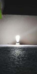 Close-up of light bulb on wall at home