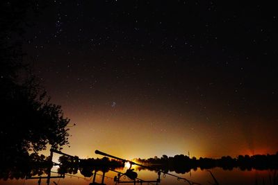 Silhouette trees against sky at night