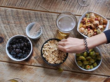 Cropped image of person having food and beer at home