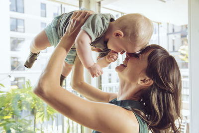 Mother lifting up her baby at home