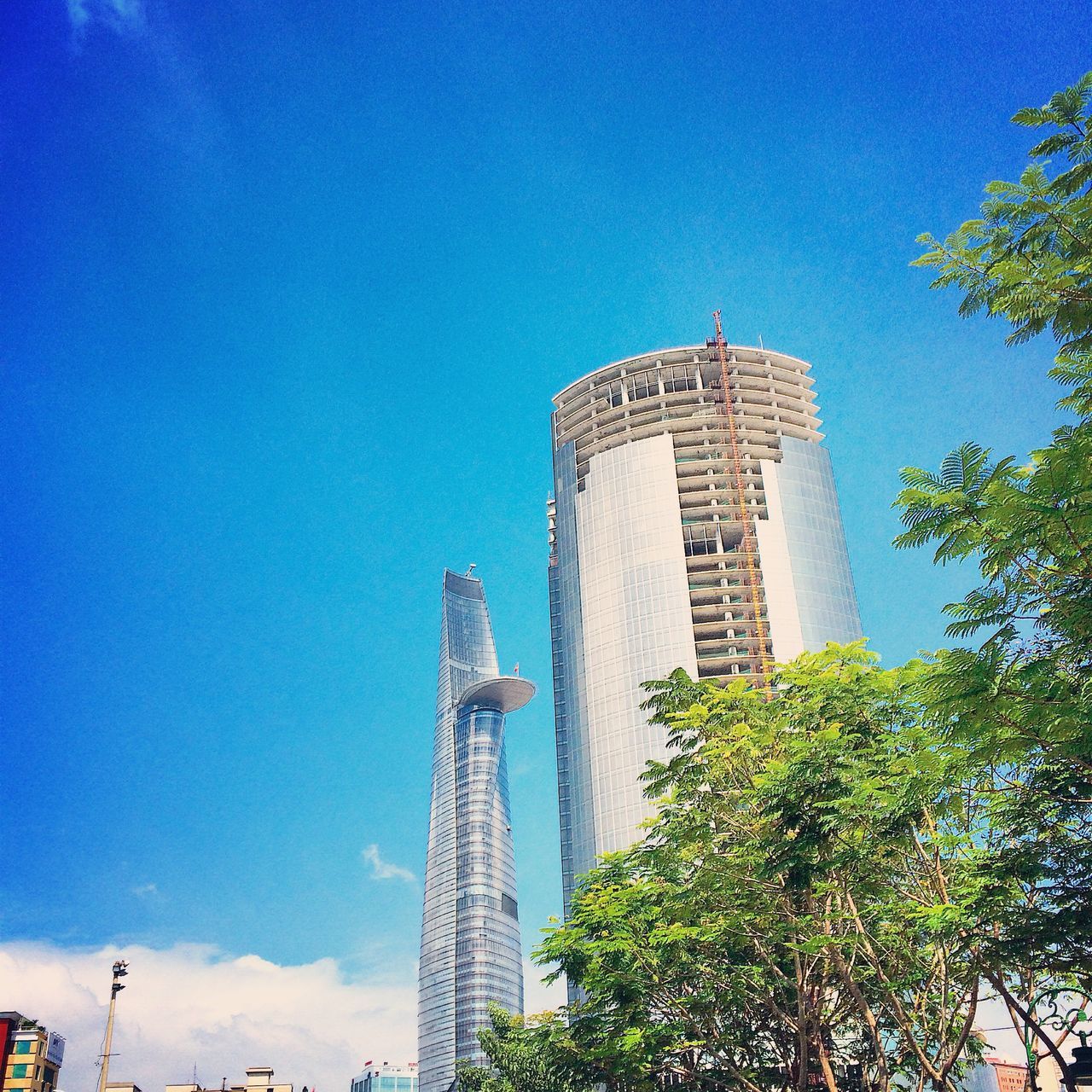 architecture, built structure, blue, low angle view, building exterior, tower, tall - high, famous place, tree, international landmark, travel destinations, capital cities, tourism, city, clear sky, travel, skyscraper, modern, eiffel tower, day