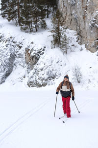 Low angle view of man skiing on snow covered field