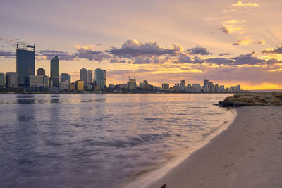 City at waterfront during sunset