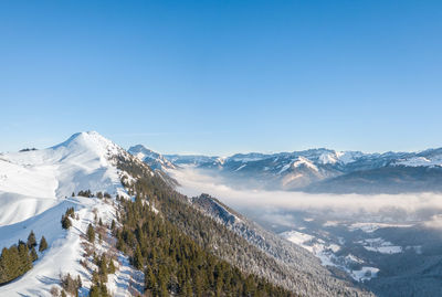 Scenic view of snowcapped mountains against clear blue sky