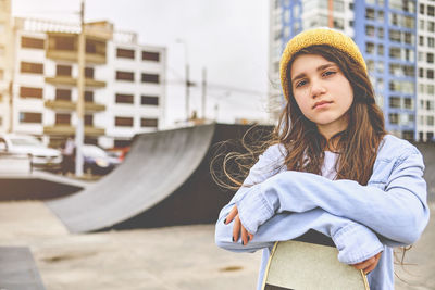 Girl having fun riding skateboards at skate park, portrait of smiling young female skateboarder 