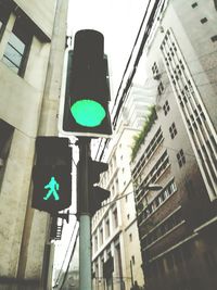 Low angle view of road signs against buildings in city