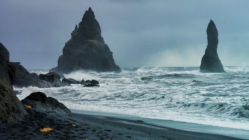 Panoramic view of rocks on beach against sky