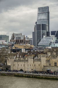 Buildings in city against cloudy sky