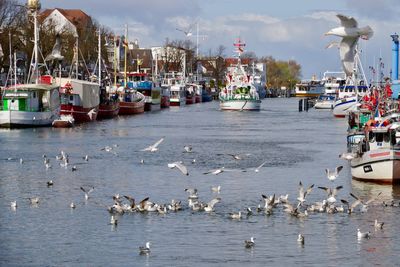 Boats in sea against sky in city