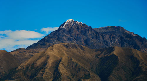 Scenic view of mountains against blue sky