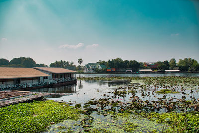 Scenic view of river by buildings against sky