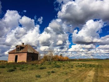 Abandoned building on field against sky