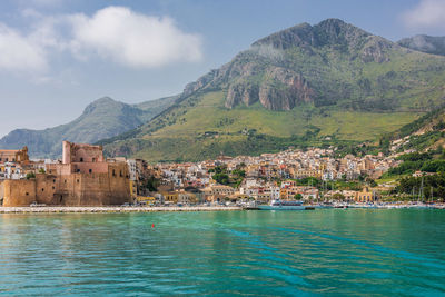 Scenic view of sea by buildings against sky