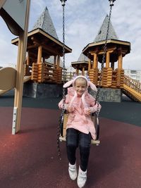 Portrait of girl holding umbrella against built structure