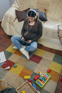 High angle view of woman sitting on sofa at home