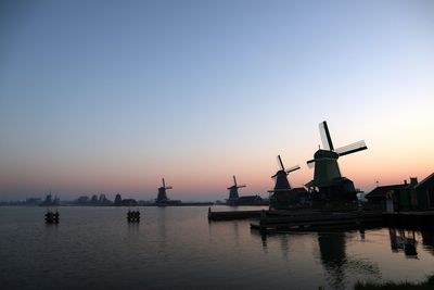 Traditional windmill against clear sky during sunset