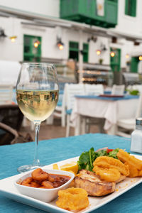 Delicious grilled seafood on plate, dish and glass of white wine in restaurant 