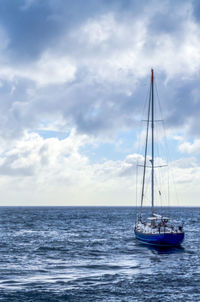 Sailboat sailing on sea against sky