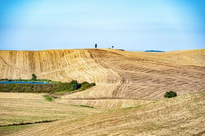 Hay bales on field against sky