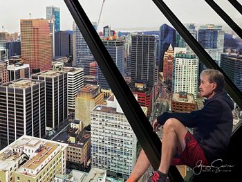 High angle view of man sitting on cityscape