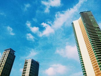 Low angle view of modern building against cloudy sky