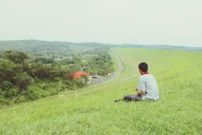 Man sitting on grassy field