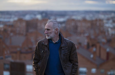 Adult man looking at city skyline of madrid, spain, during sunset