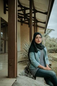 Portrait of young woman sitting outdoors