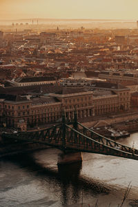 Bridge over river against buildings in city