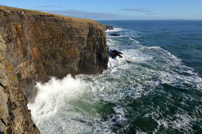 Scenic view of rock formation in sea against sky