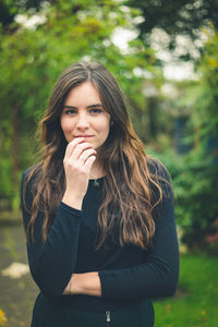 Young woman looking away while standing outdoors