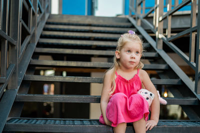 Portrait of cute girl sitting on staircase