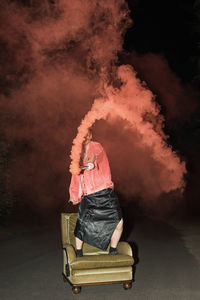 Rear view of man standing against fire