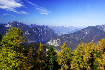 Scenic view of trees and mountains against blue sky