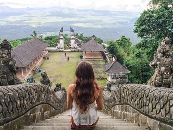 Rear view of woman sitting on steps