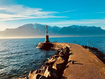 Lighthouse by sea against sky