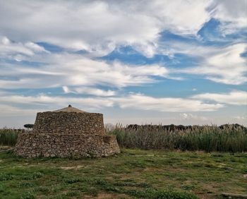 Built structure on field against sky