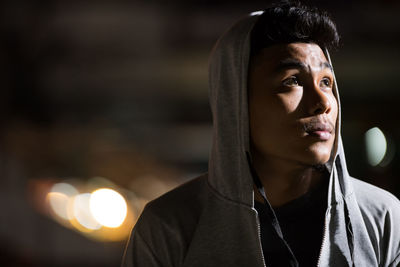 Portrait of young man looking away outdoors