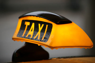 Close-up of yellow sign on car