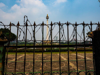 Metal fence with bridge against sky