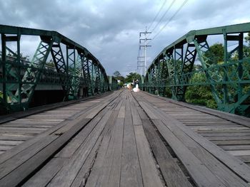 Surface level of footbridge against sky