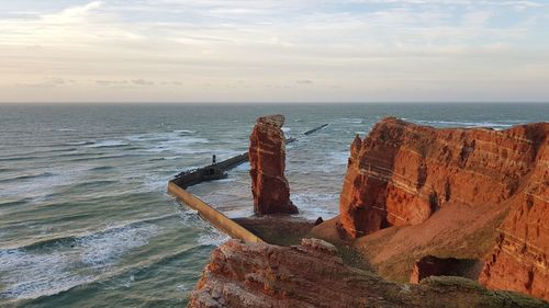 Rock formation on beach against sky