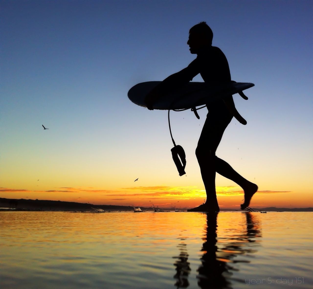 SILHOUETTE OF WOMAN JUMPING ON BEACH