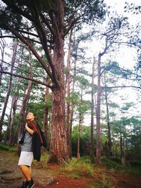 Side view of young man walking in forest